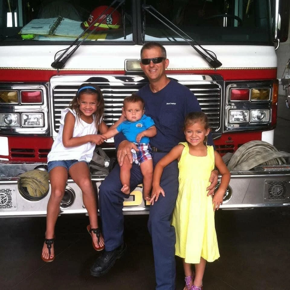 Brad Leakey with his children in front of a fire engine
